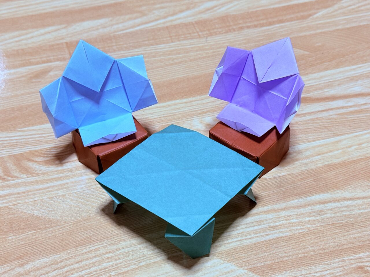 折り紙で作られたやっこさんがイスに座ってくつろいでいる写真